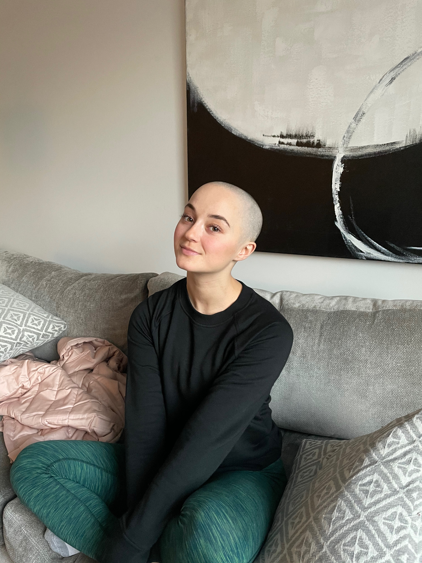 Kasey seated in front of black and white abstract artwork