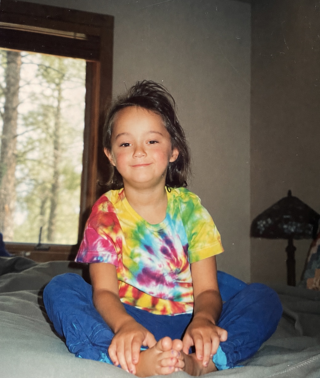 Kasey as a child in a tie-dye shirt