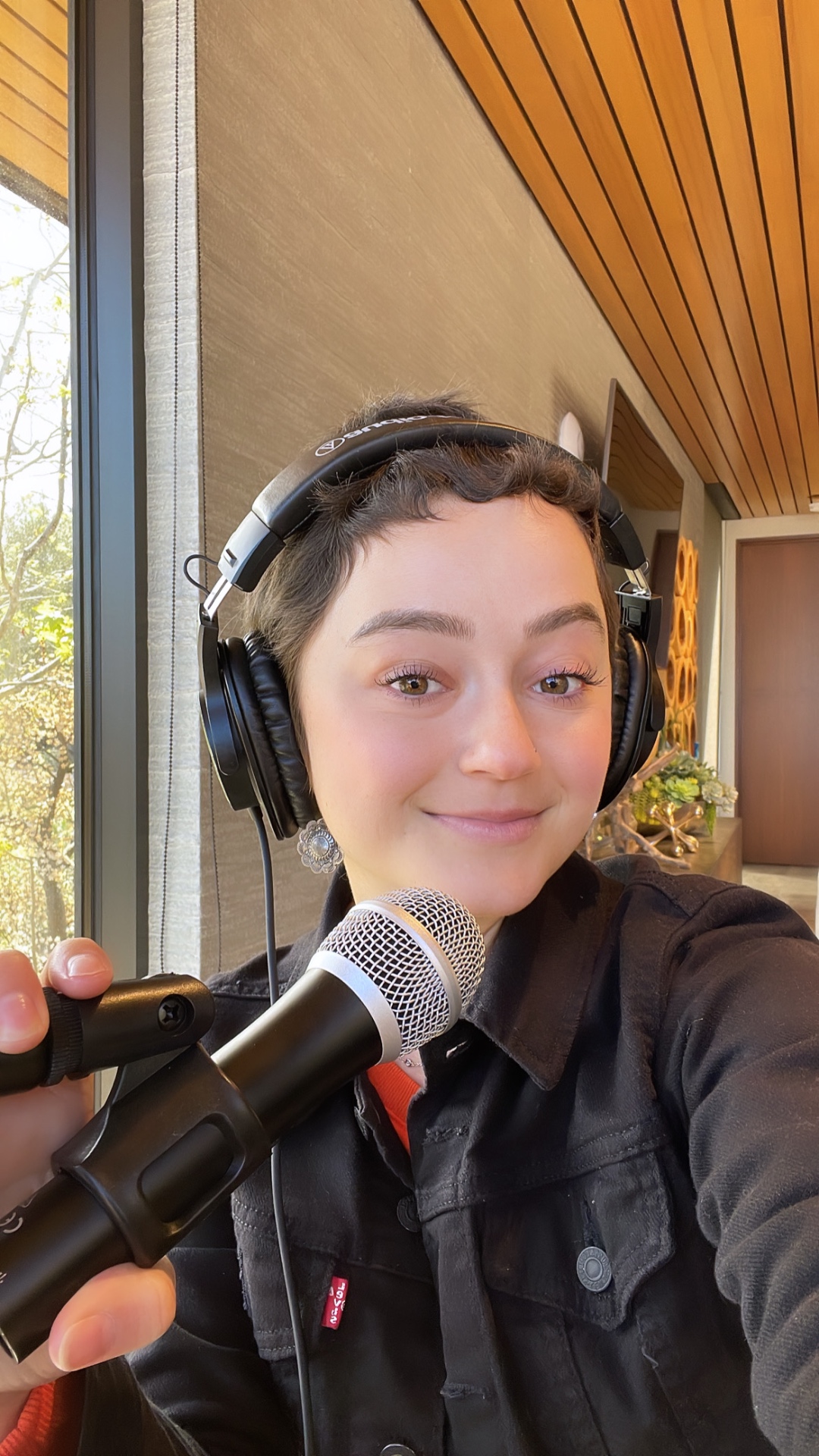 Kasey recording her podcast with headphones and microphone